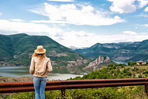 A hiking girl stands by the roadside