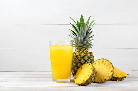 Sliced pineapples and glass of juice on wooden background, a Food & Drink Photo by AlyaAnd