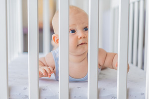 Sad baby looking through the bars of, a Person Photo by Elizaveta Galitskaya