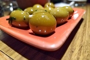 Close-up of green olives on pink plate, a Food & Drink Photo by DanFLCreativo