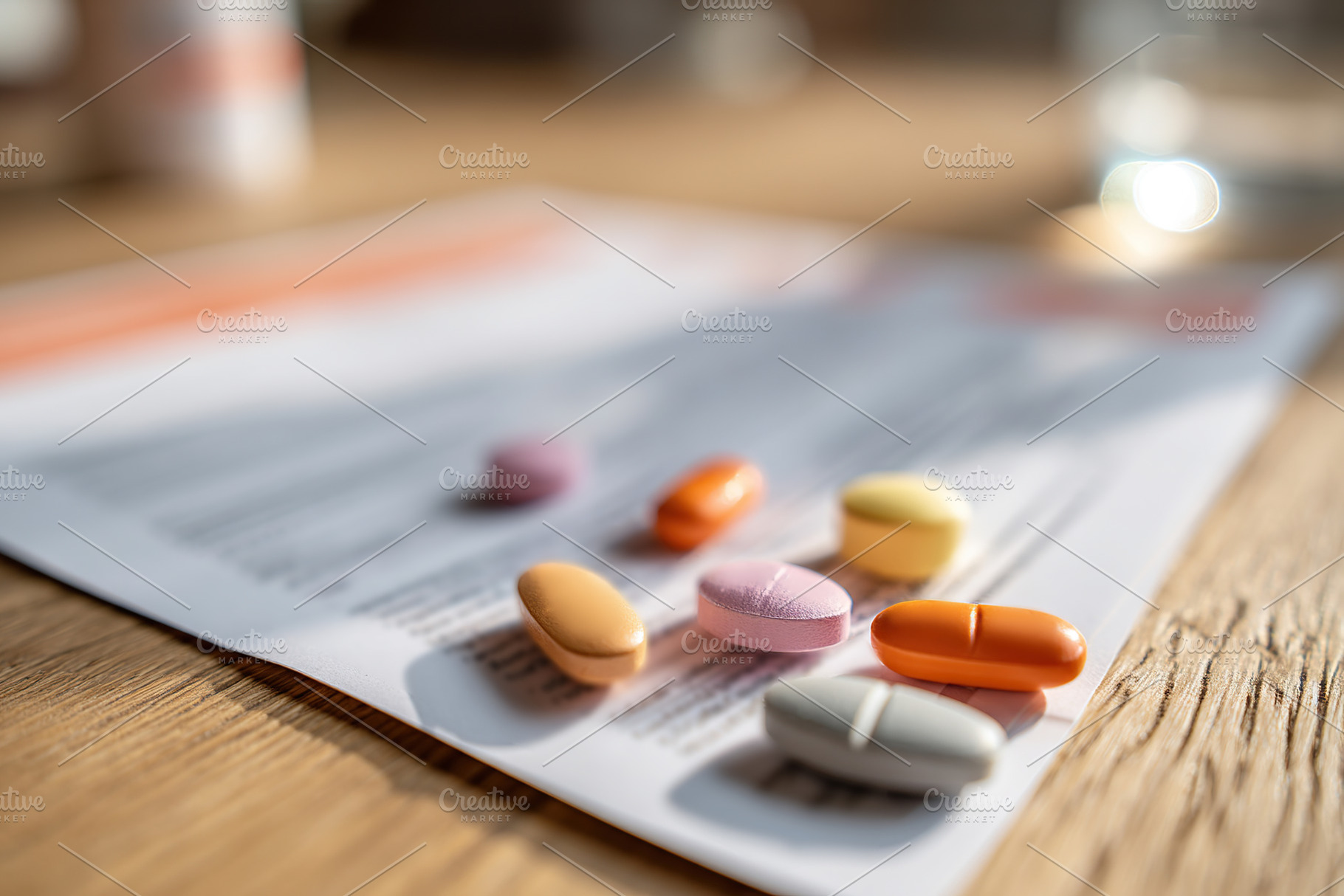Several colorful pills scattered on a prescription paper in a well-lit room, a Photo by AlyaAnd