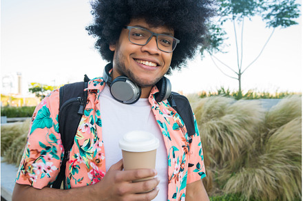 Young man holding a cup of coffee, a Person Photo by Mego-studio
