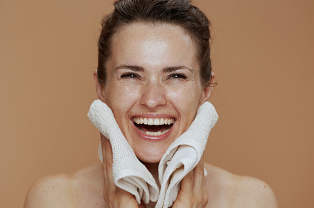 smiling modern female with towel washing face, a Person Photo by Alliance Images