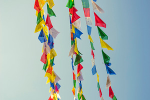 Colorful Buddhist prayer flags waving in wind against blue sky w, a Photo by Pictures for you!!!!!!!!!