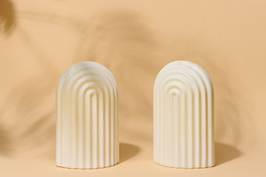 A small, white ceramic decorative arch with vertical ribbed text, a Background Photo by ndanko