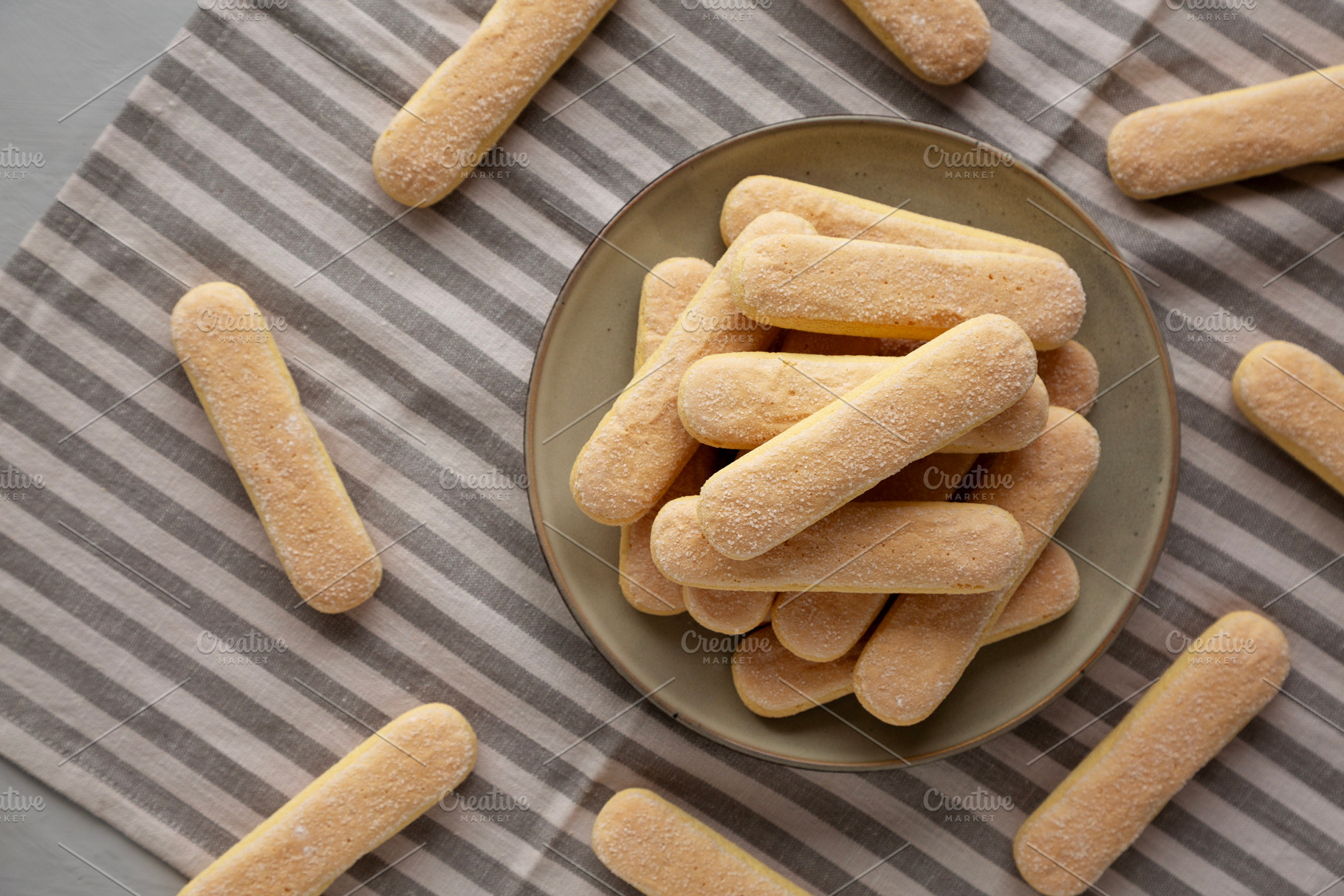 Savoiardi biscuits on a plate, top view., a Food & Drink Photo by LiudmylaChuhunova