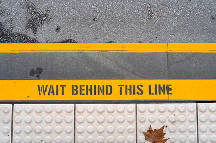 Train platform safety line with caution message on the ground