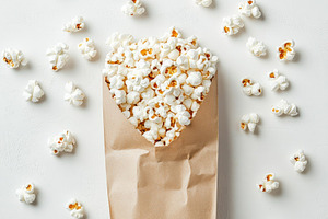 Paper bag with scattered fresh popco, a Food & Drink Photo by Pixeness Studio
