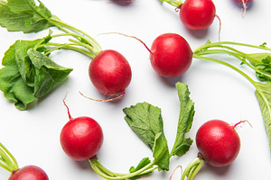 Fresh red radishes with leaves on white background, a Food & Drink Photo by Olena Rudo