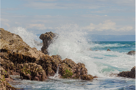 ocean waves crash against the rock, a Nature Photo by Herlan Khenz