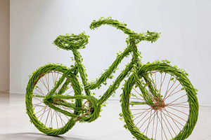 Artistic bicycle made of green vines and leaves, a Transportation Photo by AlyaAnd