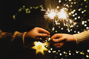 Happy New Year! Burning sparklers in hands on background of chri, a Holiday Photo by Sonjachni