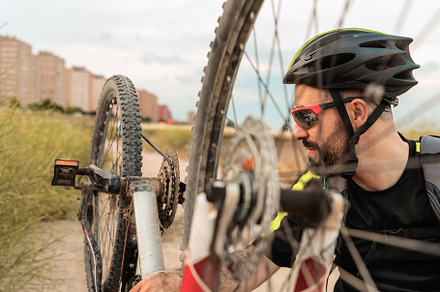 cyclist checking the wheels of his b, a Sports & Recreation Photo by Perpis
