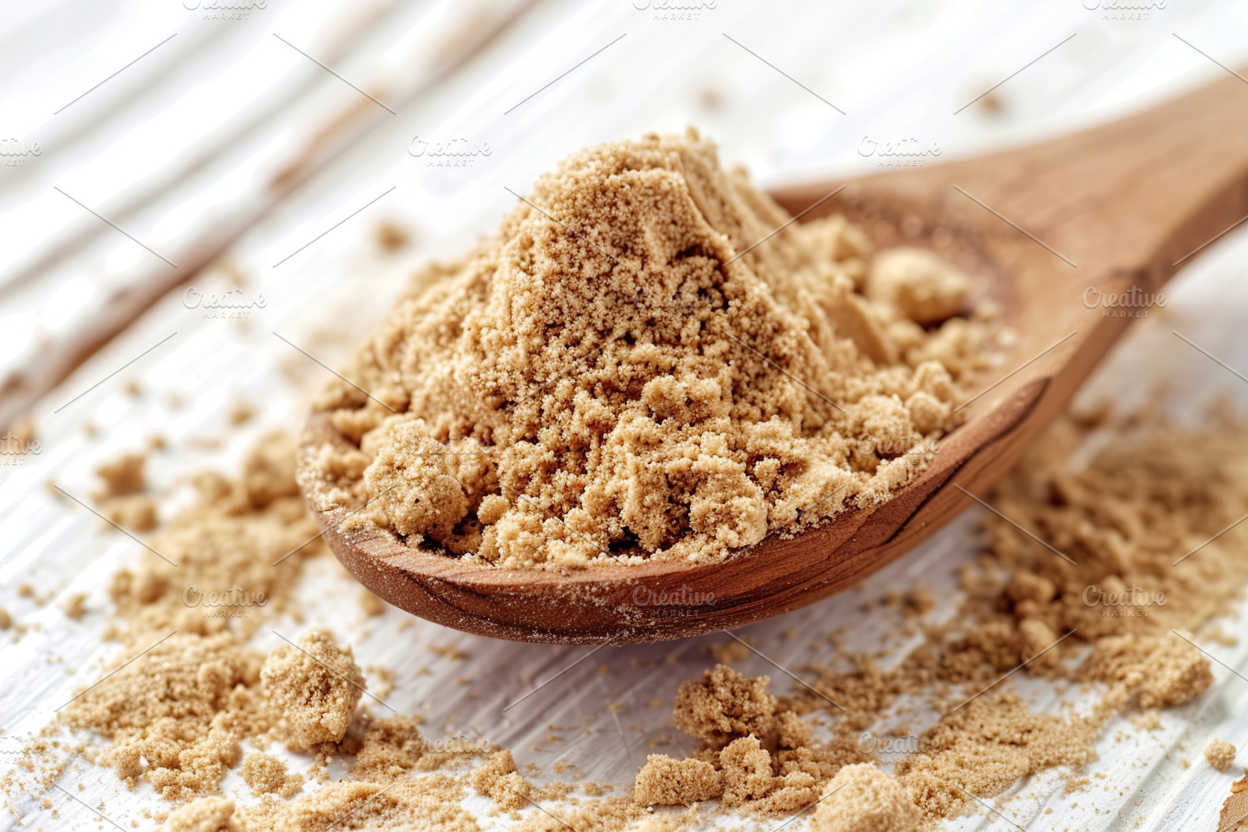 Ground dry ginger in wooden spoon on white wooden background, a Food & Drink Photo by AlyaAnd