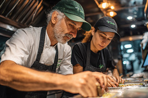Chefs preparing food in a food truck, a Photo by Pixeness Studio