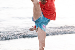 Happy girl in Santa hat playing at the beach during Christmas, a Person Photo by etorres69