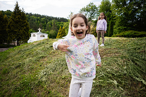Joyful children playing in a grassy field on a sunny day, a Person Photo by AS photostudio
