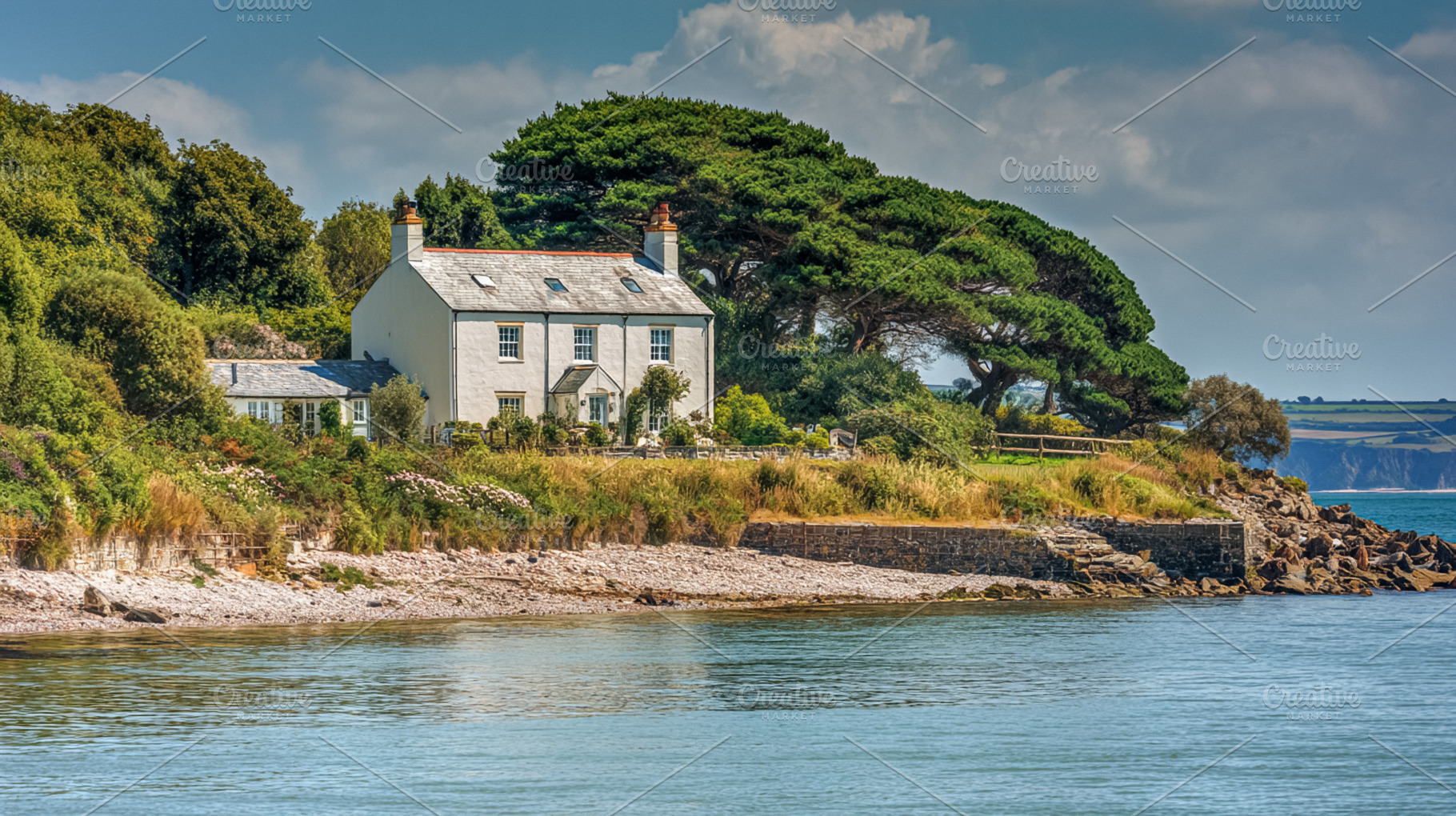 Coastal white house nestled on a green hillside with lush trees,, a Photo by Studio ANNA