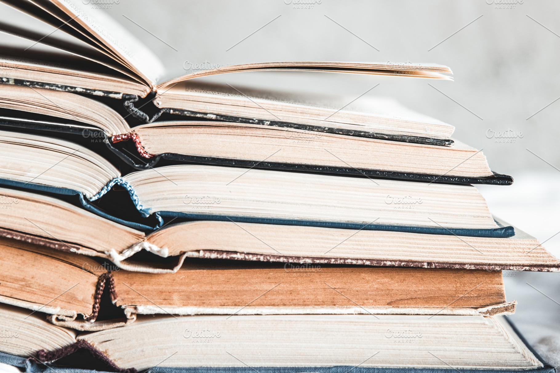 Opened books in a stack on a light featuring grunge, retro, and vintage, a School & Education Photo by OS