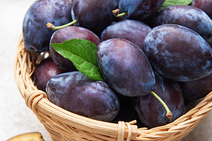 Fresh plums in wicker basket, healthy eating concept, a Food & Drink Photo by Olena Rudo