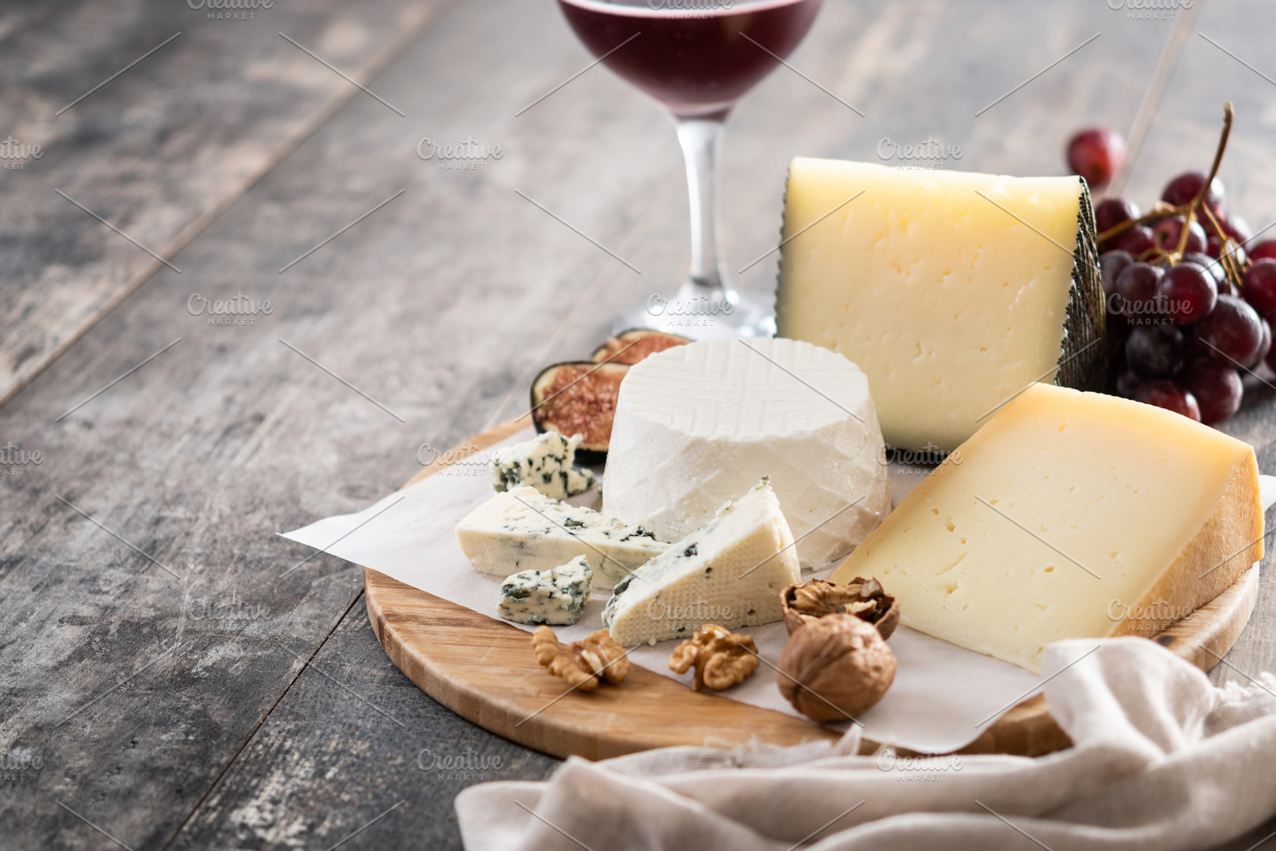 Board of different cheeses with nuts, figs and grapes, a Food & Drink Photo by etorres69
