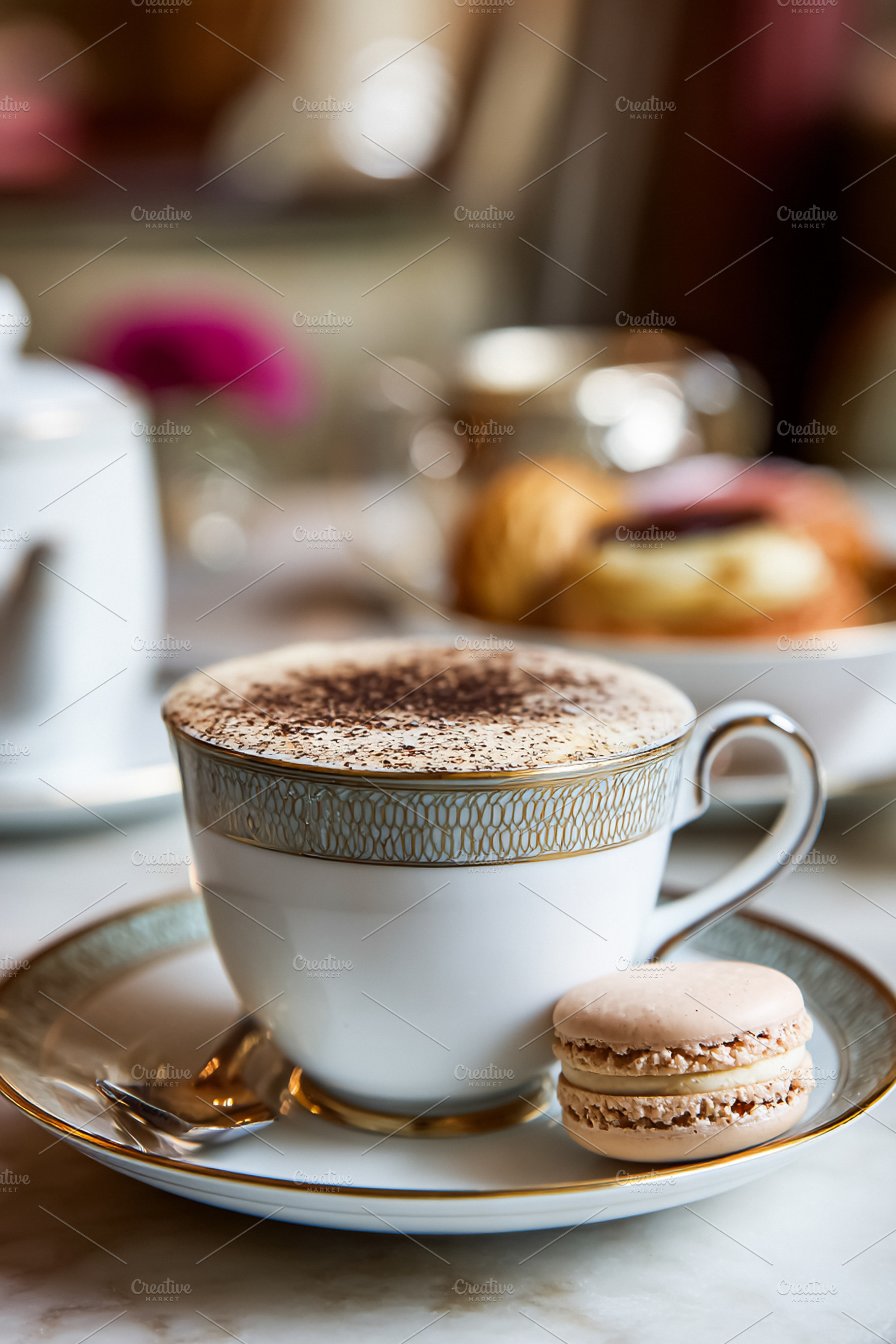 Cappuccino with cocoa powder and a macaron cookie on an elegant, a Food & Drink Photo by Studio ANNA