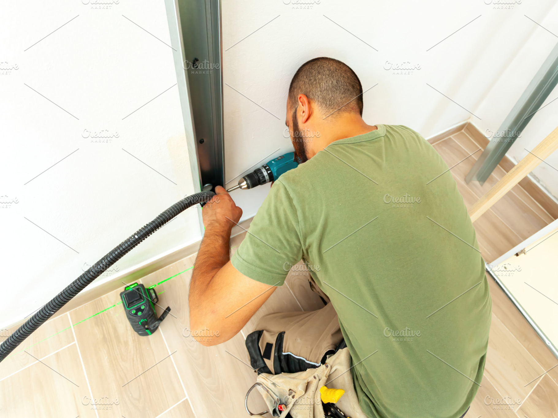 Electrician installing corrugated pipe for electrical wiring in plasterboard wa, an Industrial Photo by Antonio Gravante Market