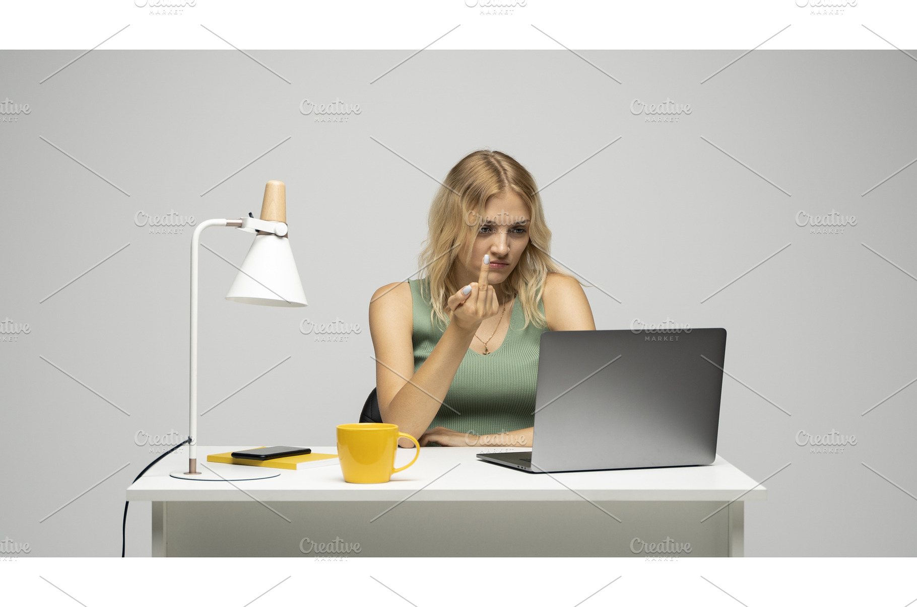 Young blonde woman showing middle, a Technology Photo by volodymyrshtun13795