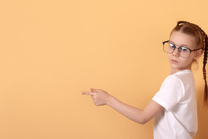 Young girl with glasses and braided hair pointing sideways again, a Person Photo by Ales Munt