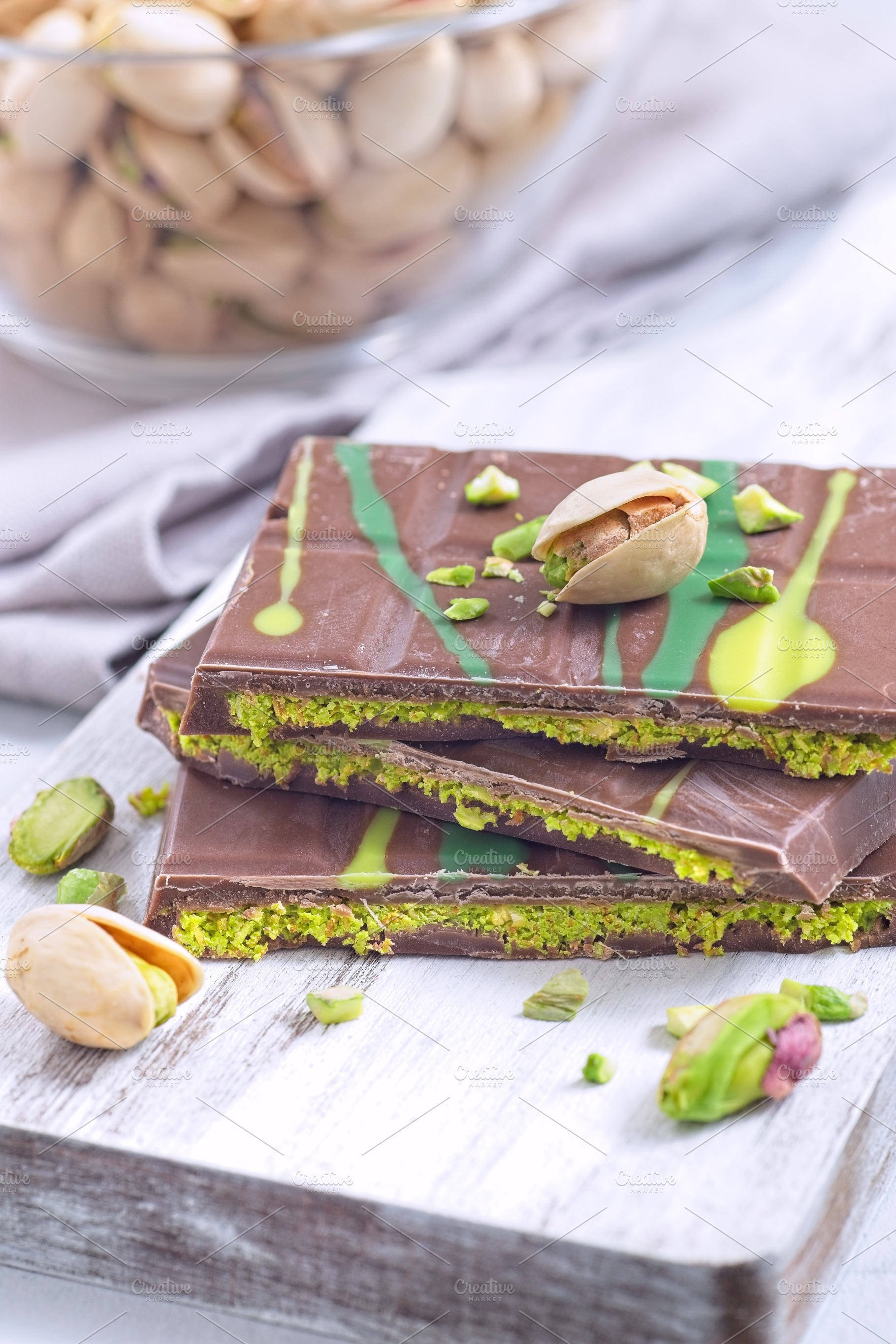 Dubai style milk chocolate bar with pistachio and kadaifi filing, lying on cutt, a Food & Drink Photo by iuliia_n