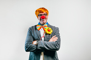 Businessman enjoying being a cheerful clown in costume, a Person Photo by karrastock