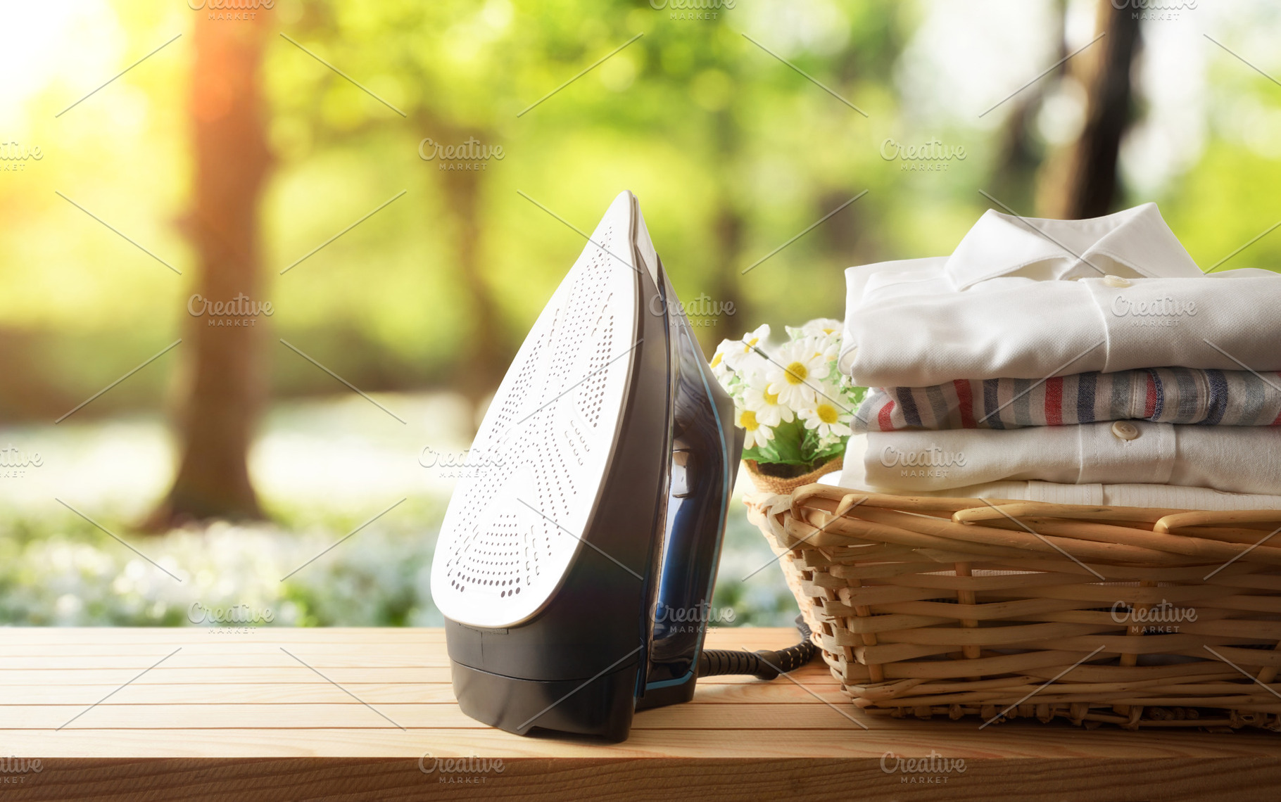 Iron showing sole with basket full of shirts in nature, a Technology Photo by Davizro's Market