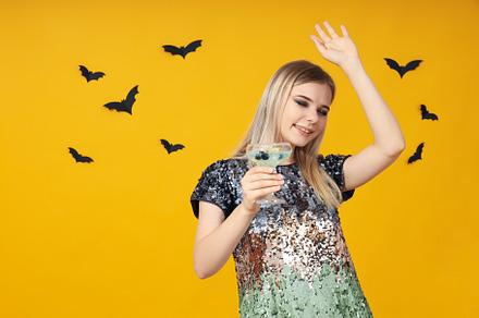Concept of Halloween, young woman on yellow background, a Person Photo by AtlasStudio PRO