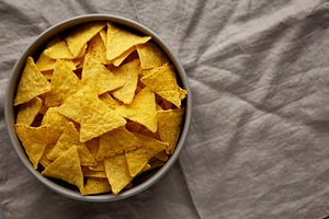 Homemade Tortilla Corn Chips in a Bowl, top view. Overhead, from, a Food & Drink Photo by LiudmylaChuhunova
