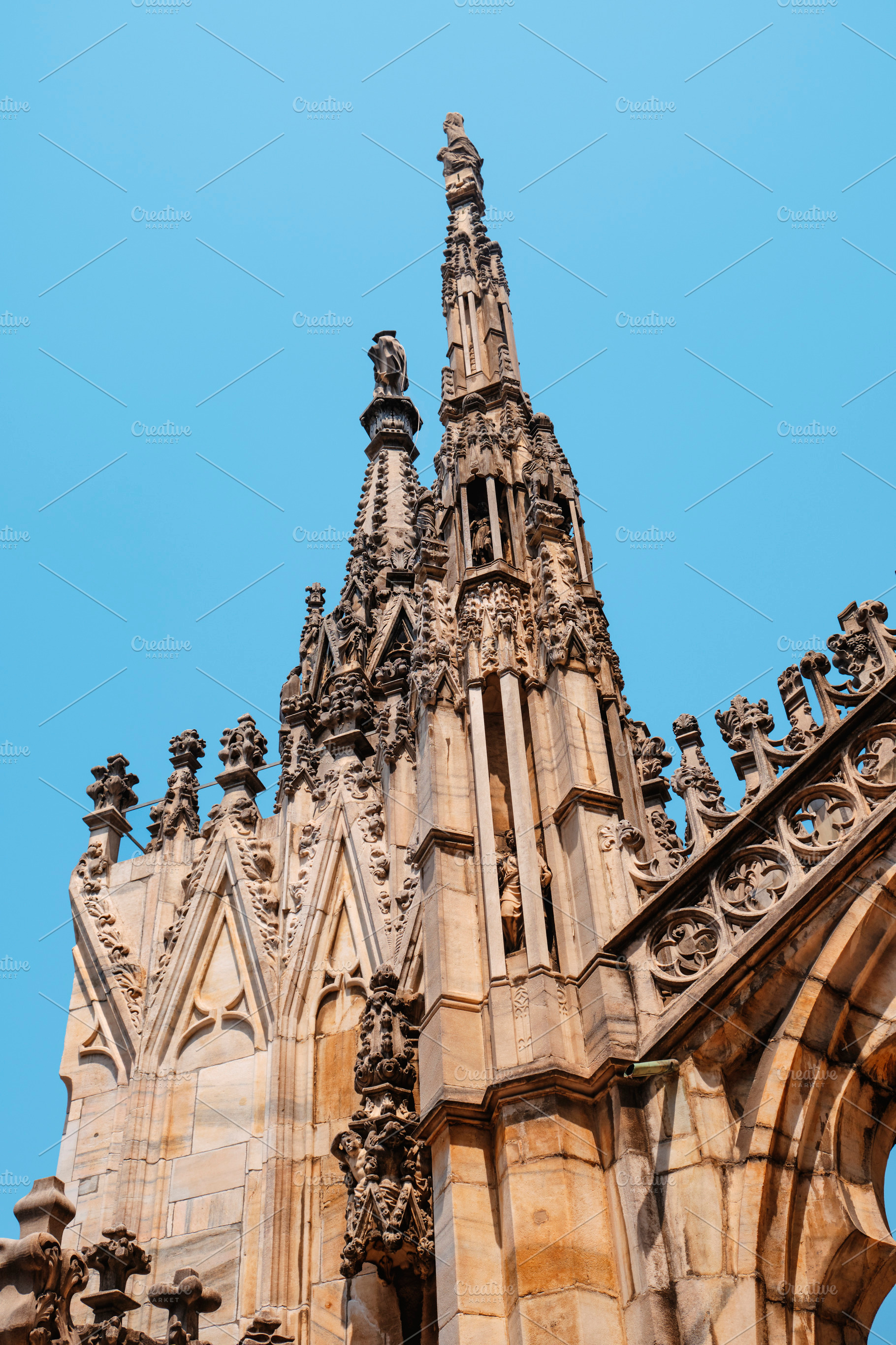 gothic spires and statues of the Duomo di Milano, a Photo by Nito