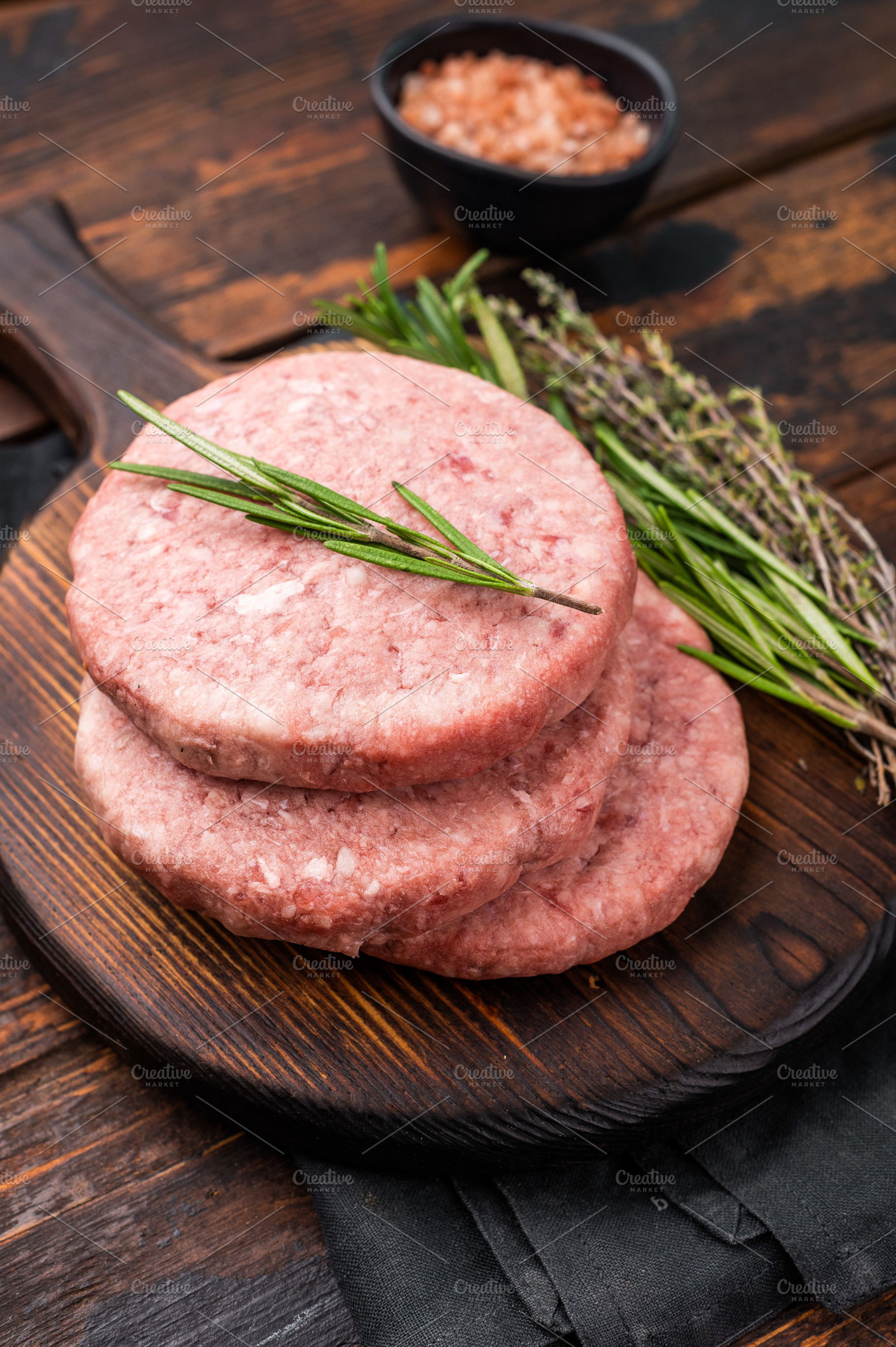 Uncooked beef and pork meat patty on a wooden board, inviting yo, a Food & Drink Photo by composter-box@mail.ru