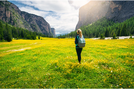 Girl with backpack on the meadow