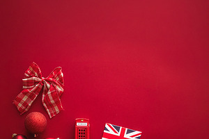 Christmas in London concept with Union Jack flag, red telephone box, bow, and b, a Photo by Studio ANNA