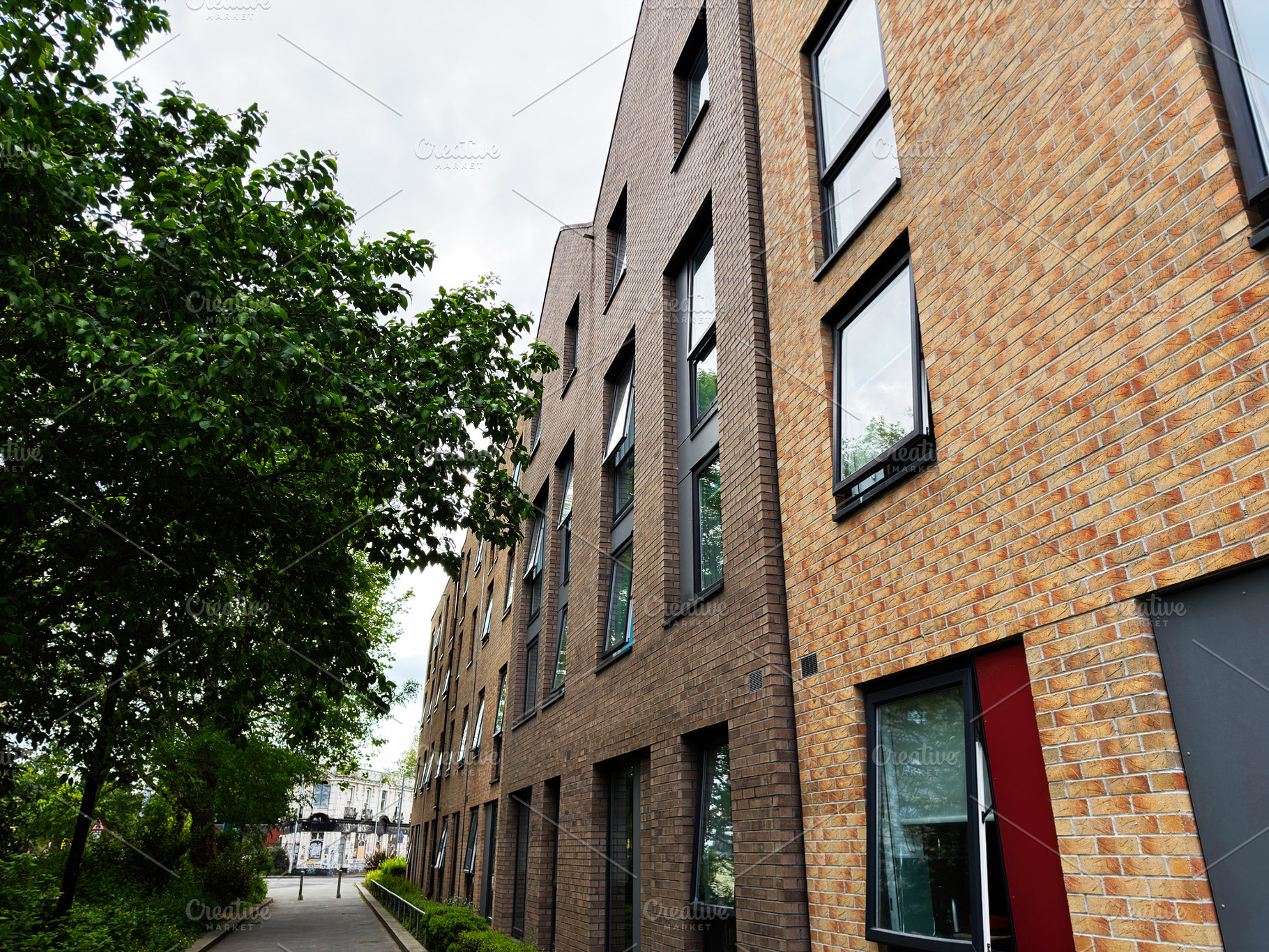 Modern brick apartment building and tree lined walkway on a resi, a Photo by AS photostudio