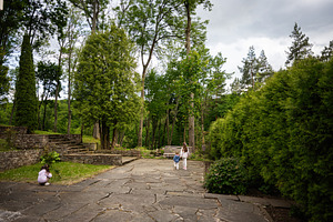 A serene garden with a pathway and people enjoying nature's tranquility, a Person Photo by AS photostudio