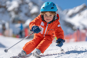 Young child skiing on snowy slope, a Sports & Recreation Photo by AlyaAnd