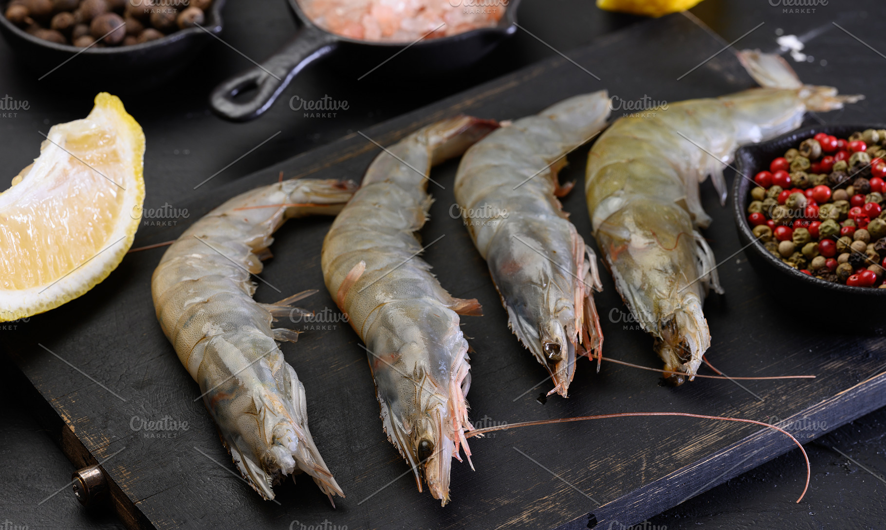 Raw shrimp with spices on a wooden board, a Food & Drink Photo by ndanko