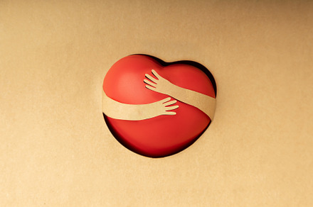 Love Yourself Concept. Paper Cut as Arms Embracing a Red Heart S