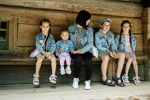 Family seated on a wooden bench outdoors in casual denim wear, a Person Photo by AS photostudio
