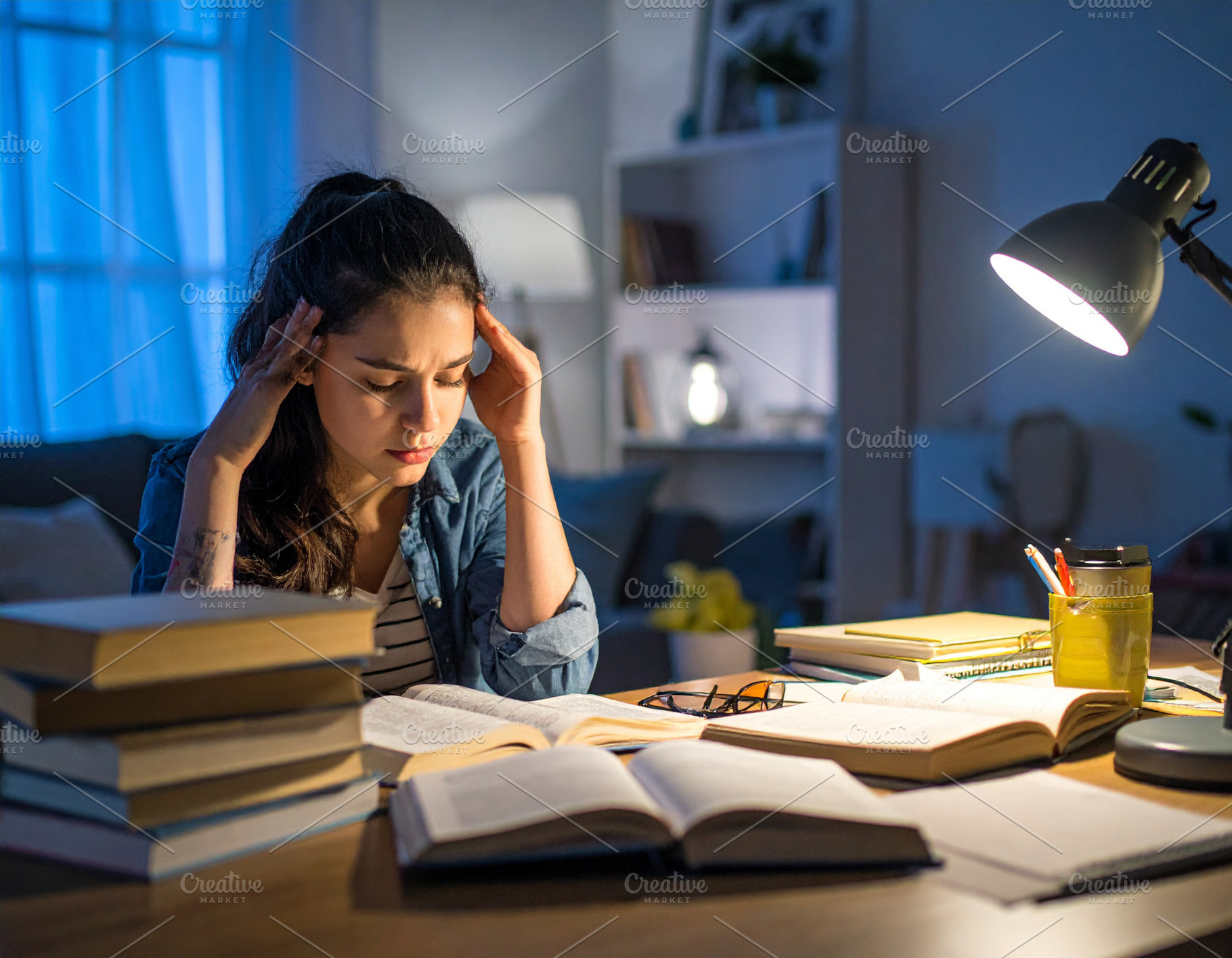 Stressed student surrounded by books and papers at bedroom, a Person Photo by DanFLCreativo