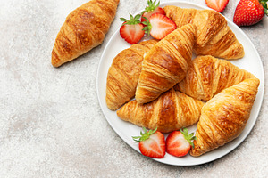 Freshly baked croissants with strawberries creating a delightful, a Food & Drink Photo by Olena Rudo