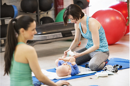 Mother changing diaper during group, a Sports & Recreation Photo by HalfPoint