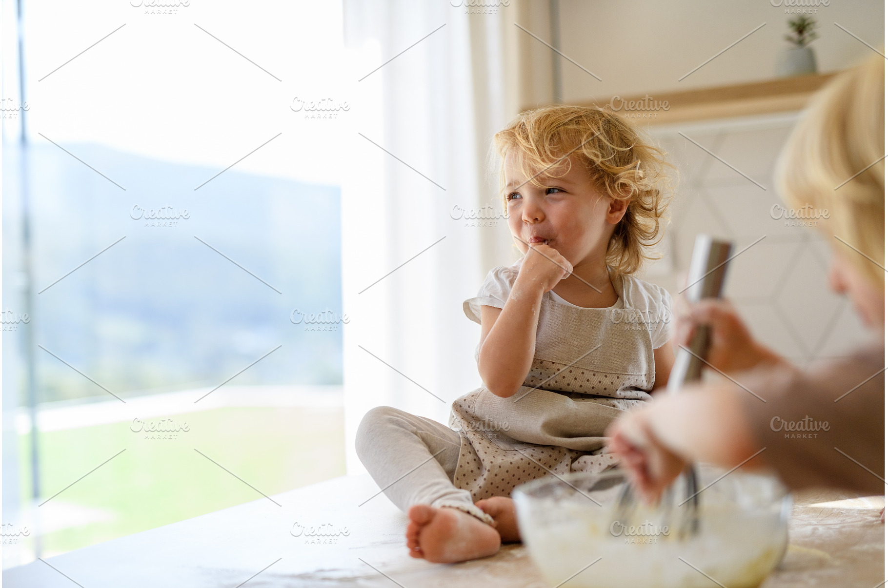 Little cute girl sitting on kitchen, a Food & Drink Photo by HalfPoint