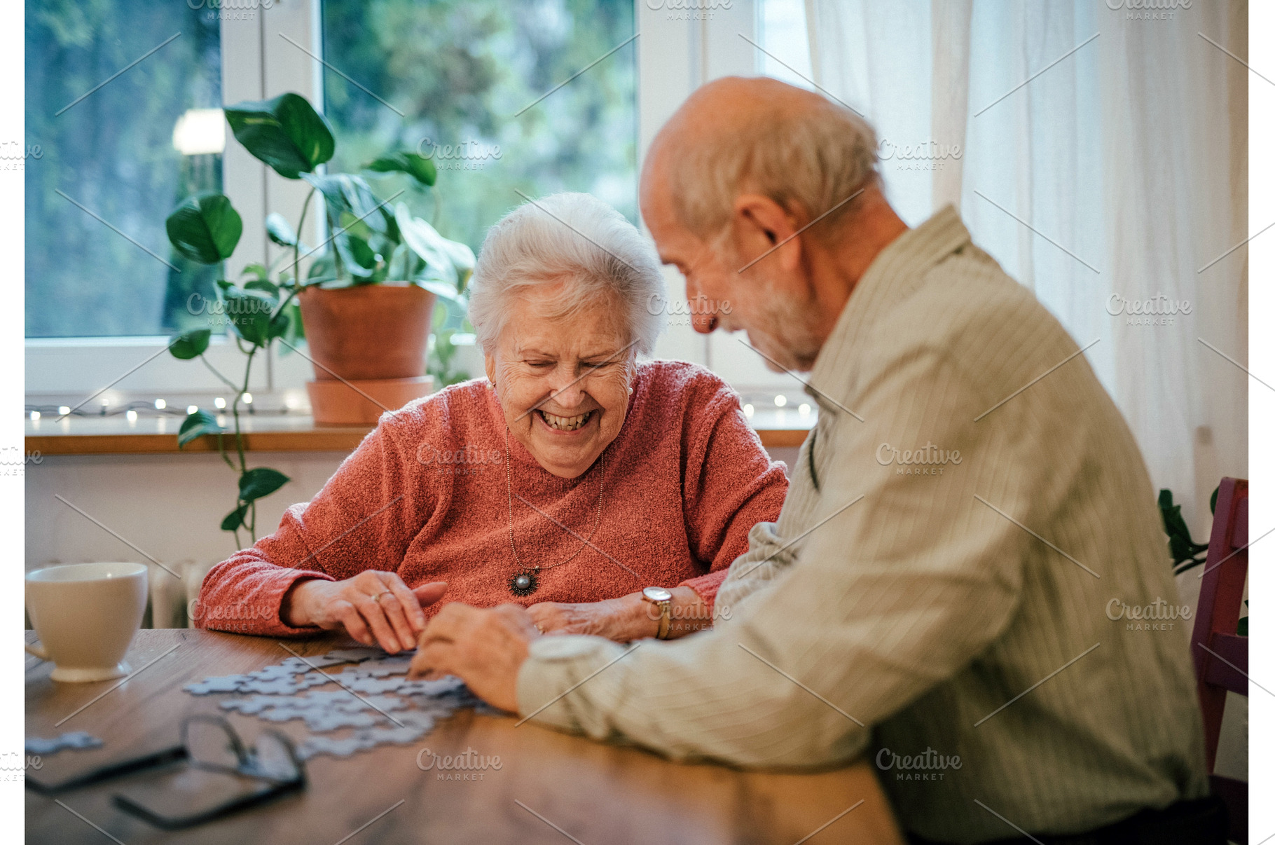 Senior couple solving jigsaw puzzle, a Person Photo by HalfPoint