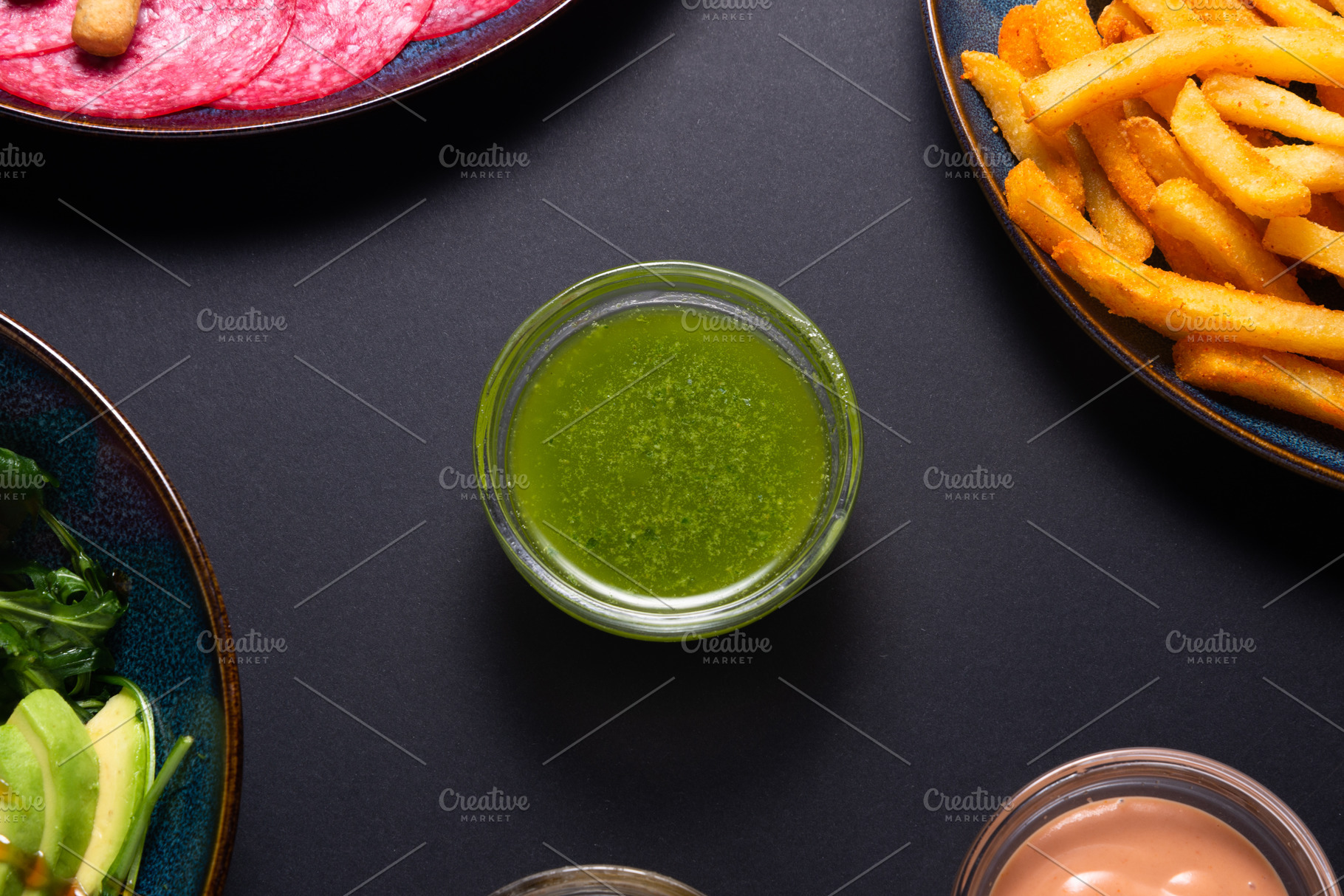 Green pesto sauce in a small glass bowl on a black background. B, a Food & Drink Photo by MDBildes